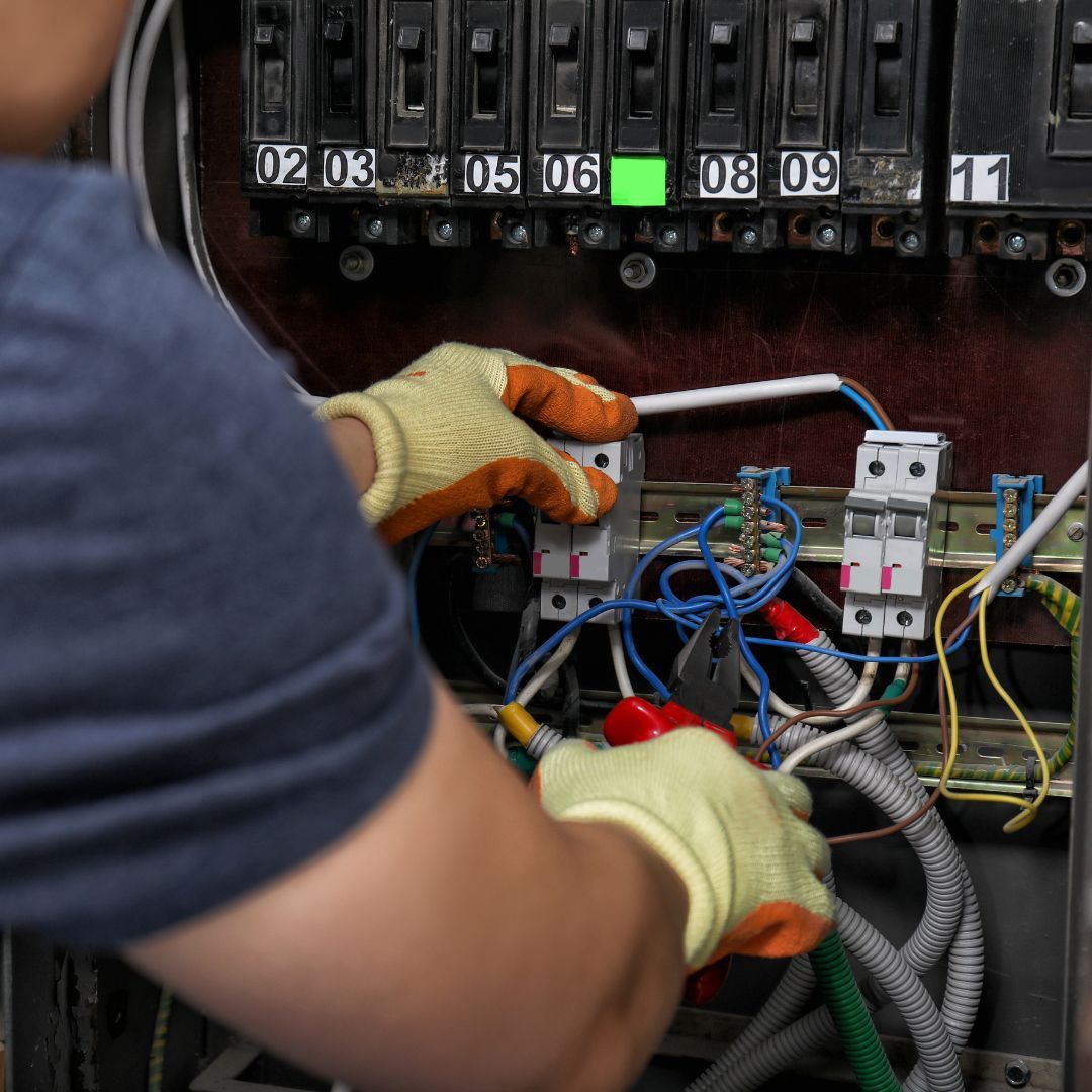 A man is working on an electrical box with the number 30 on it