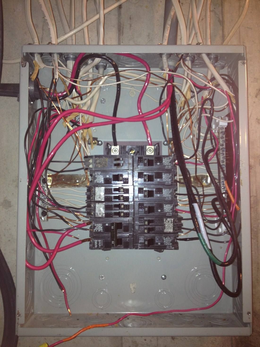 A very messy electrical box with wires coming out of it