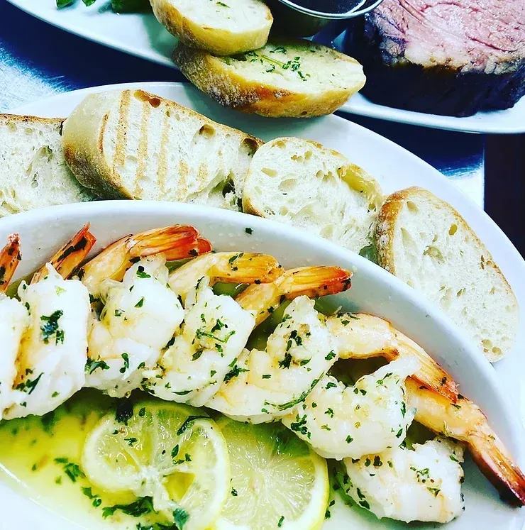 A white plate topped with shrimp bread and lemon slices