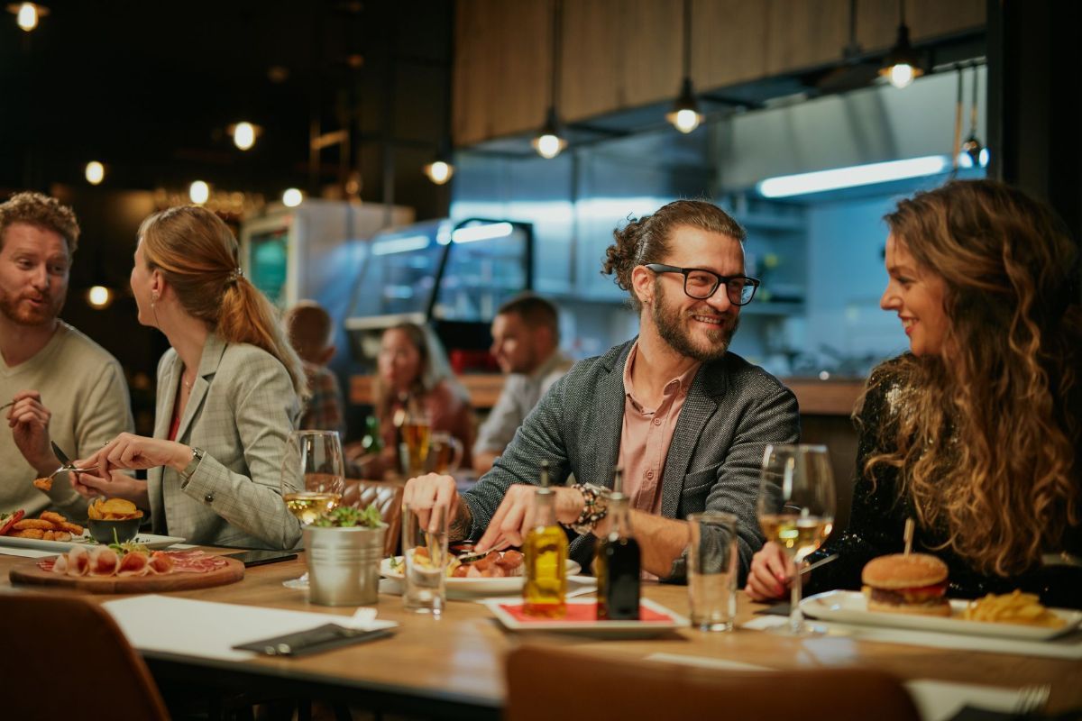 A group of people are sitting at a table in a restaurant eating food.