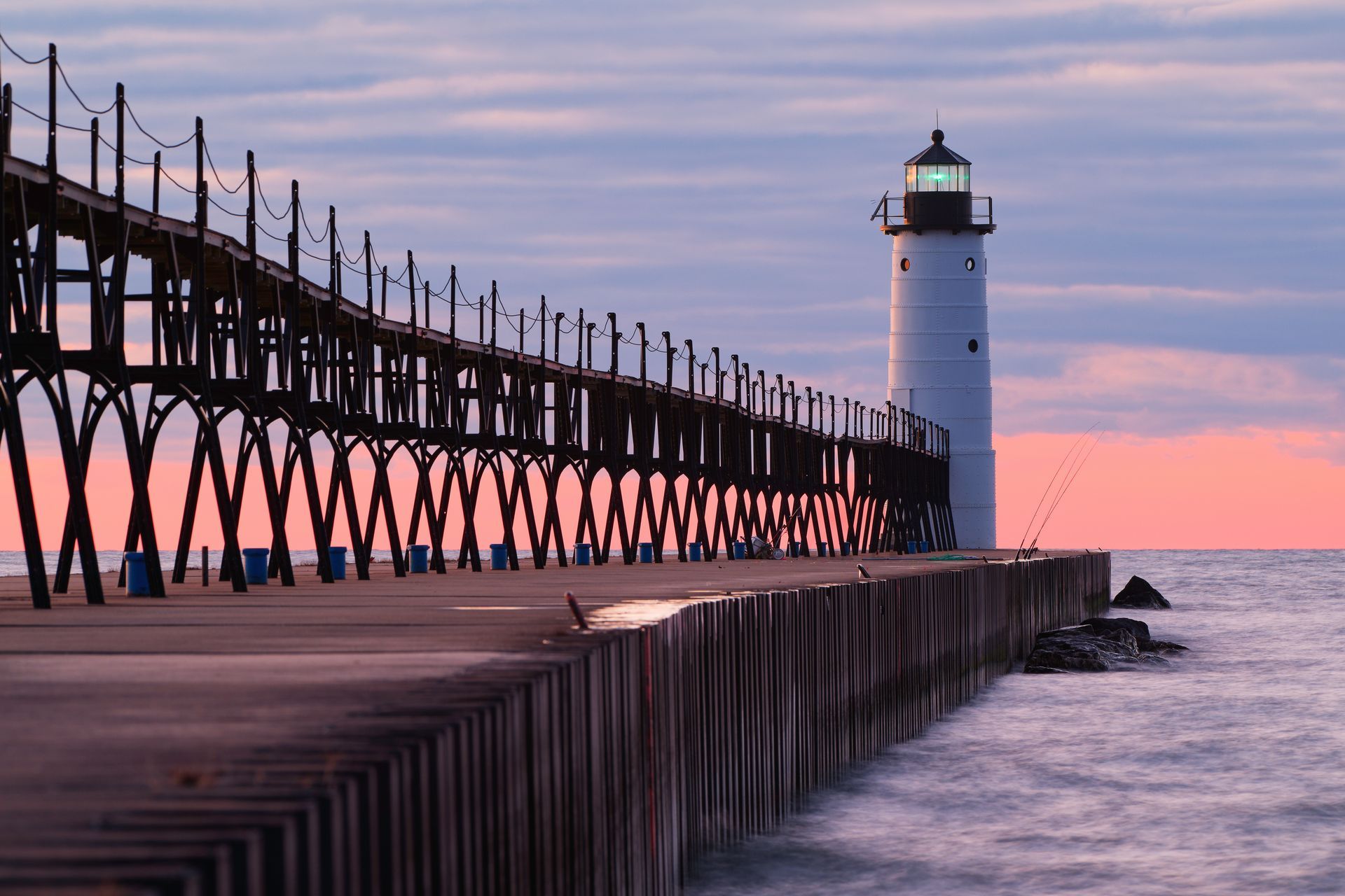 A lighthouse is sitting on top of a pier overlooking the ocean.