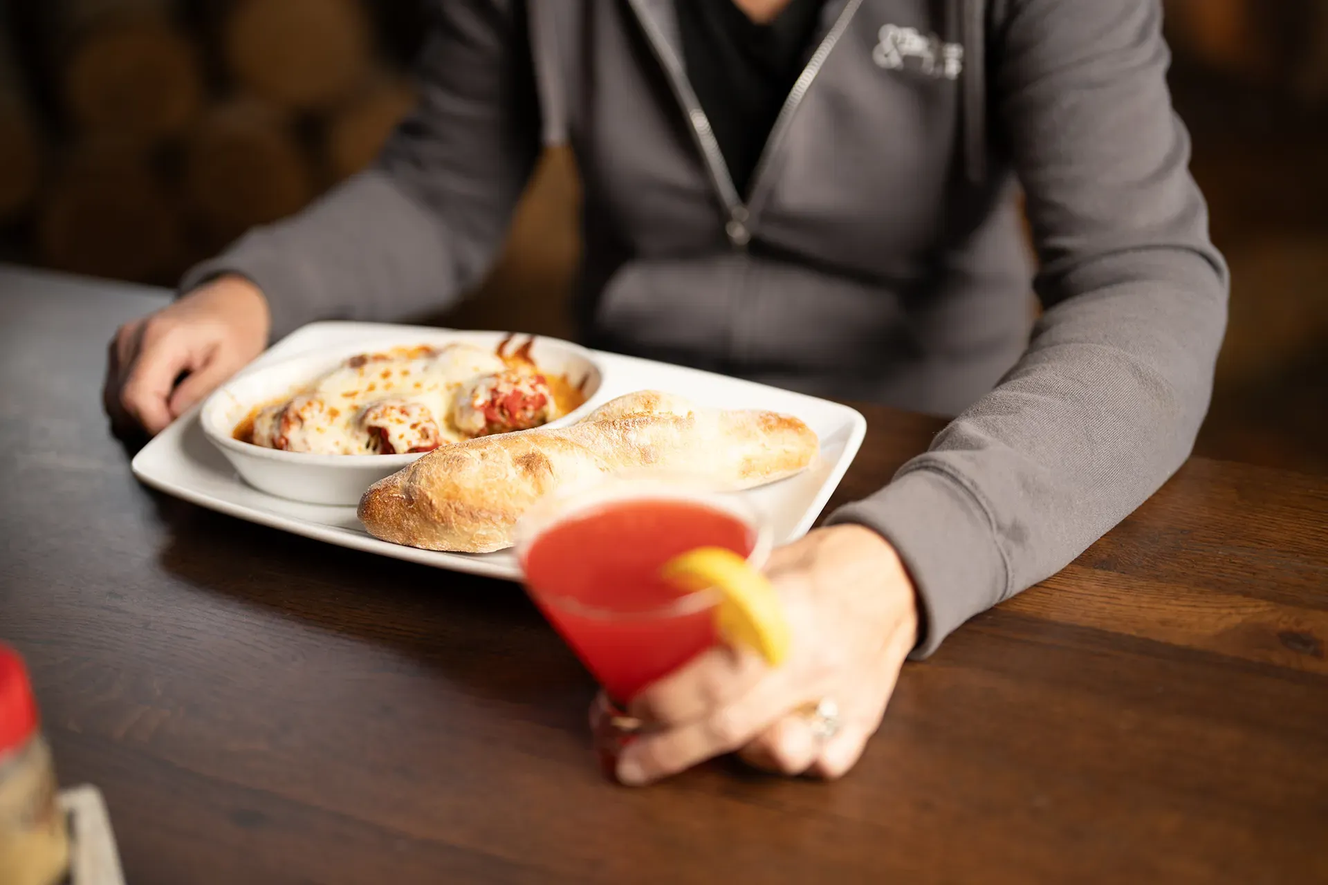 A person is sitting at a table with a plate of food and a drink.