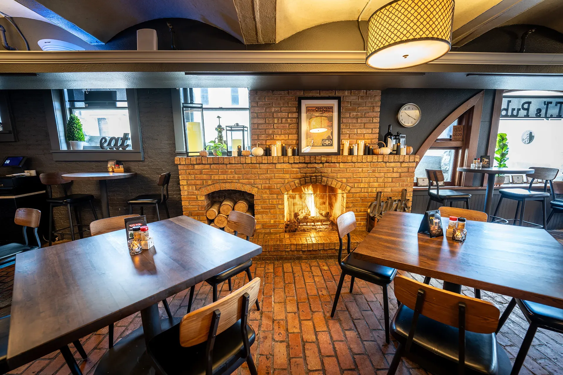 A restaurant with tables and chairs and a fireplace.