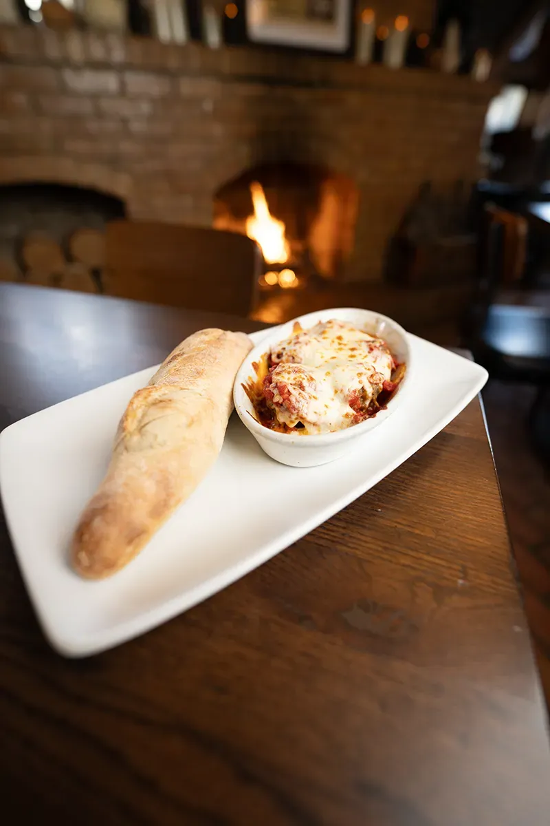 A plate of food with bread and a bowl of food on a table.