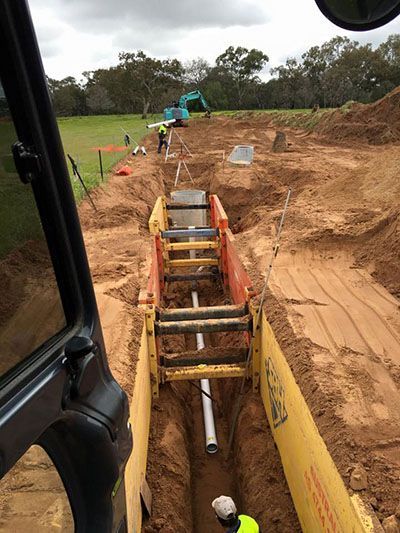 A construction site with pipes being installed in the dirt.