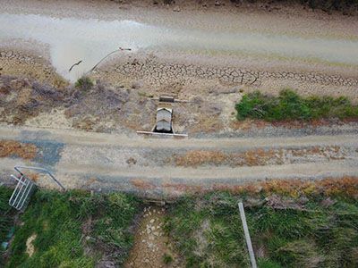 An aerial view of a truck driving down a dirt road.