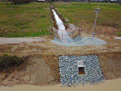An aerial view of a stream running through a field.