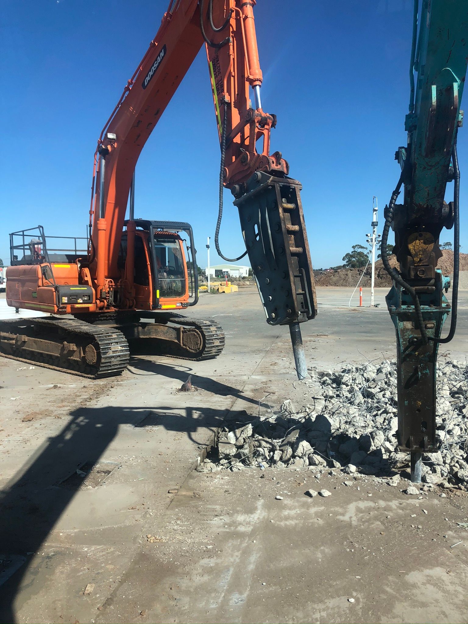A large orange excavator is working on a construction site.