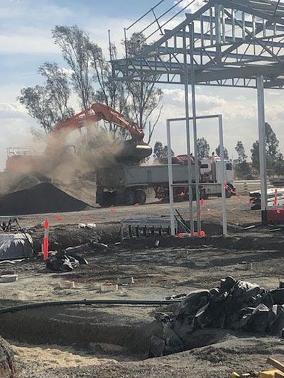 A construction site with a truck and an excavator.