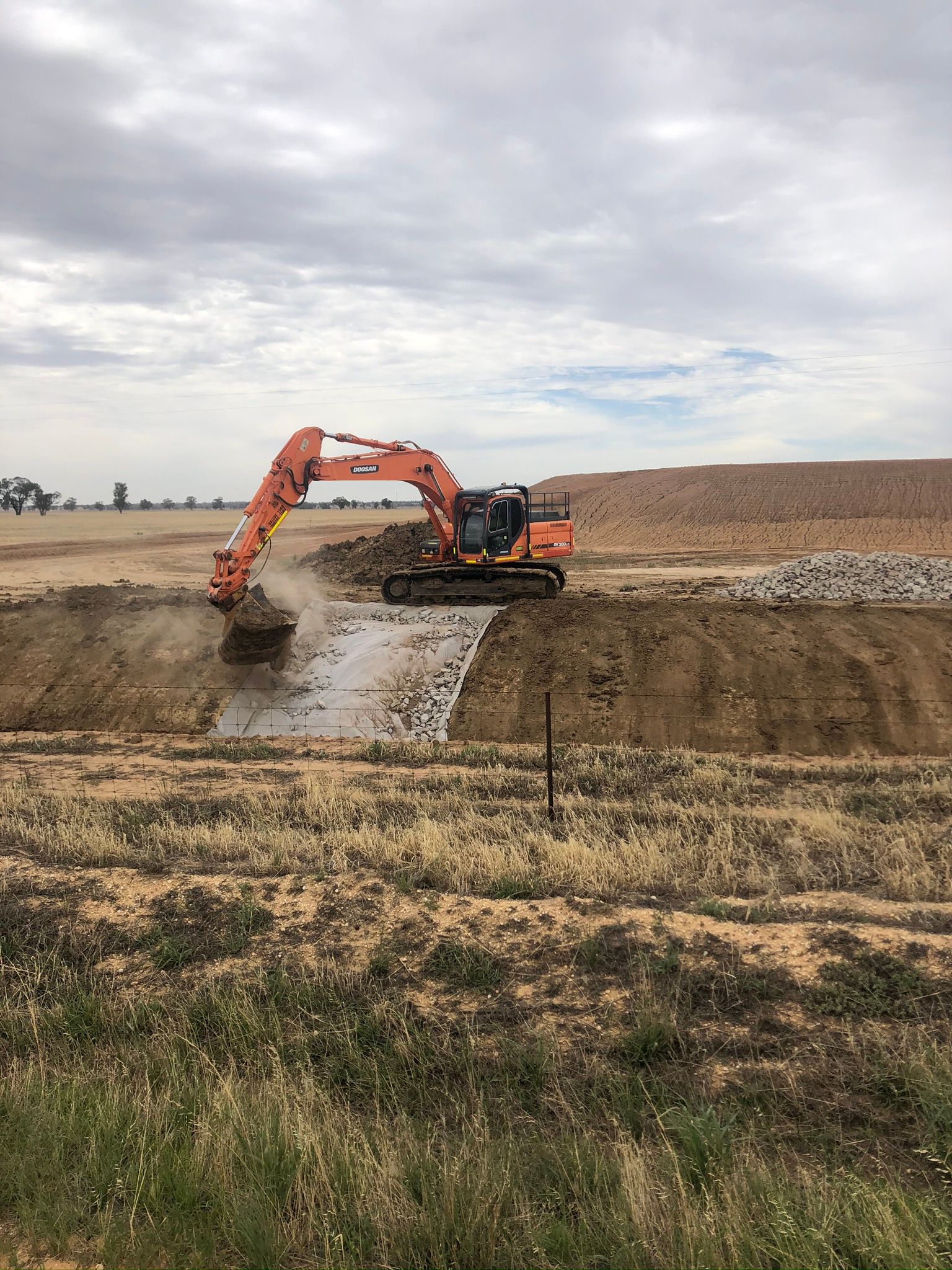 A large excavator is digging a hole in a field.