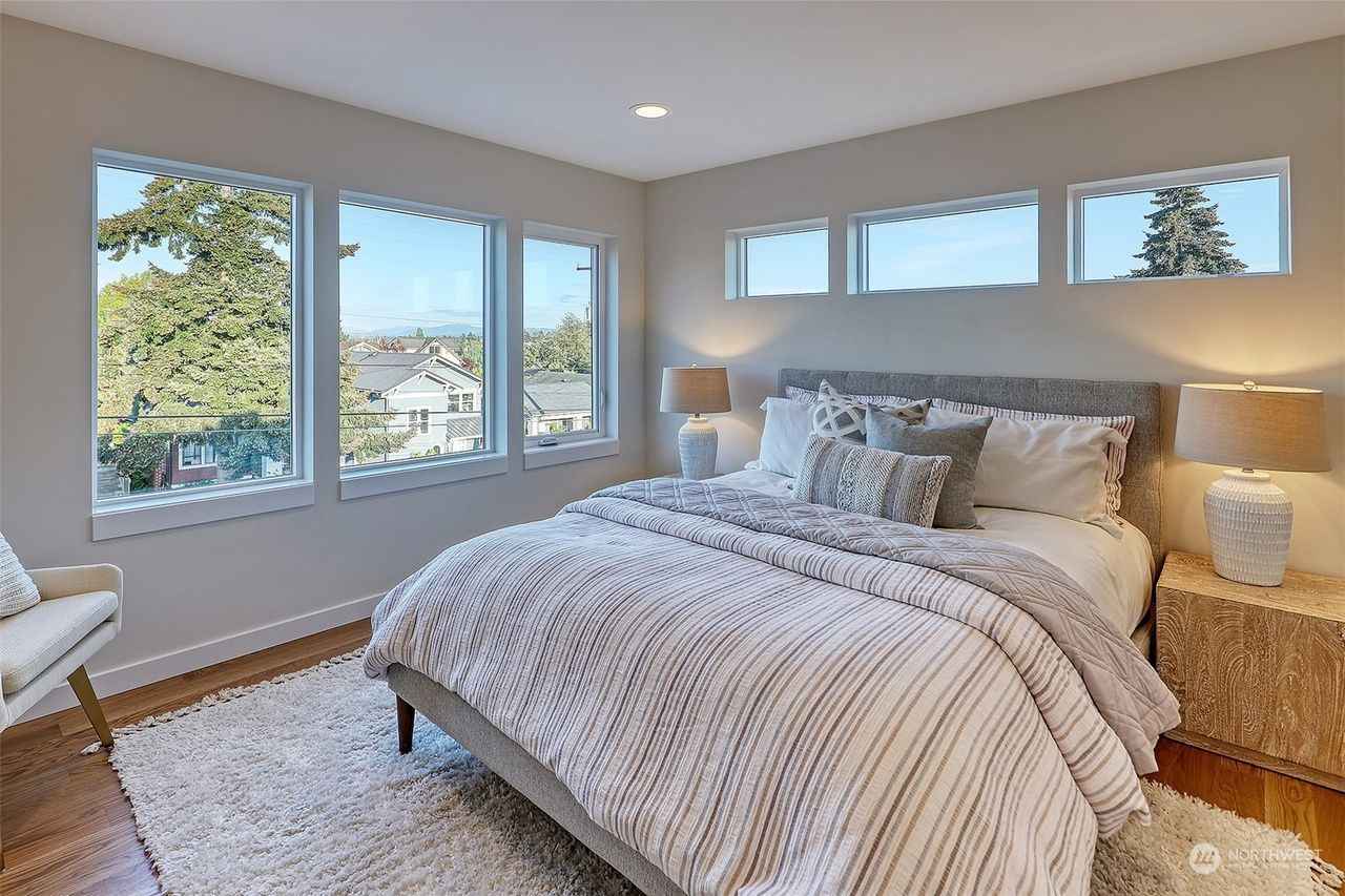 A bedroom with a large bed and lots of windows