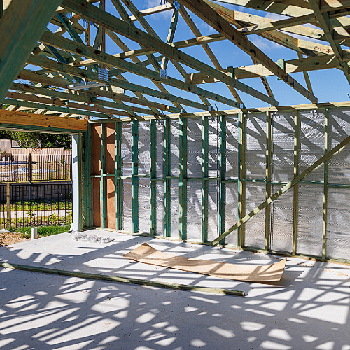 The inside of a building under construction with a lot of wooden beams.