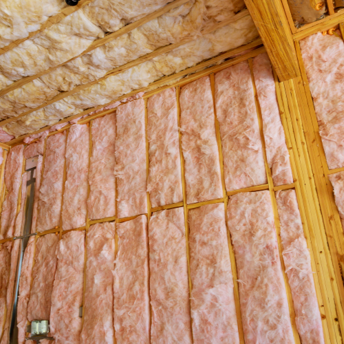 A room with a lot of pink insulation on the walls and ceiling.