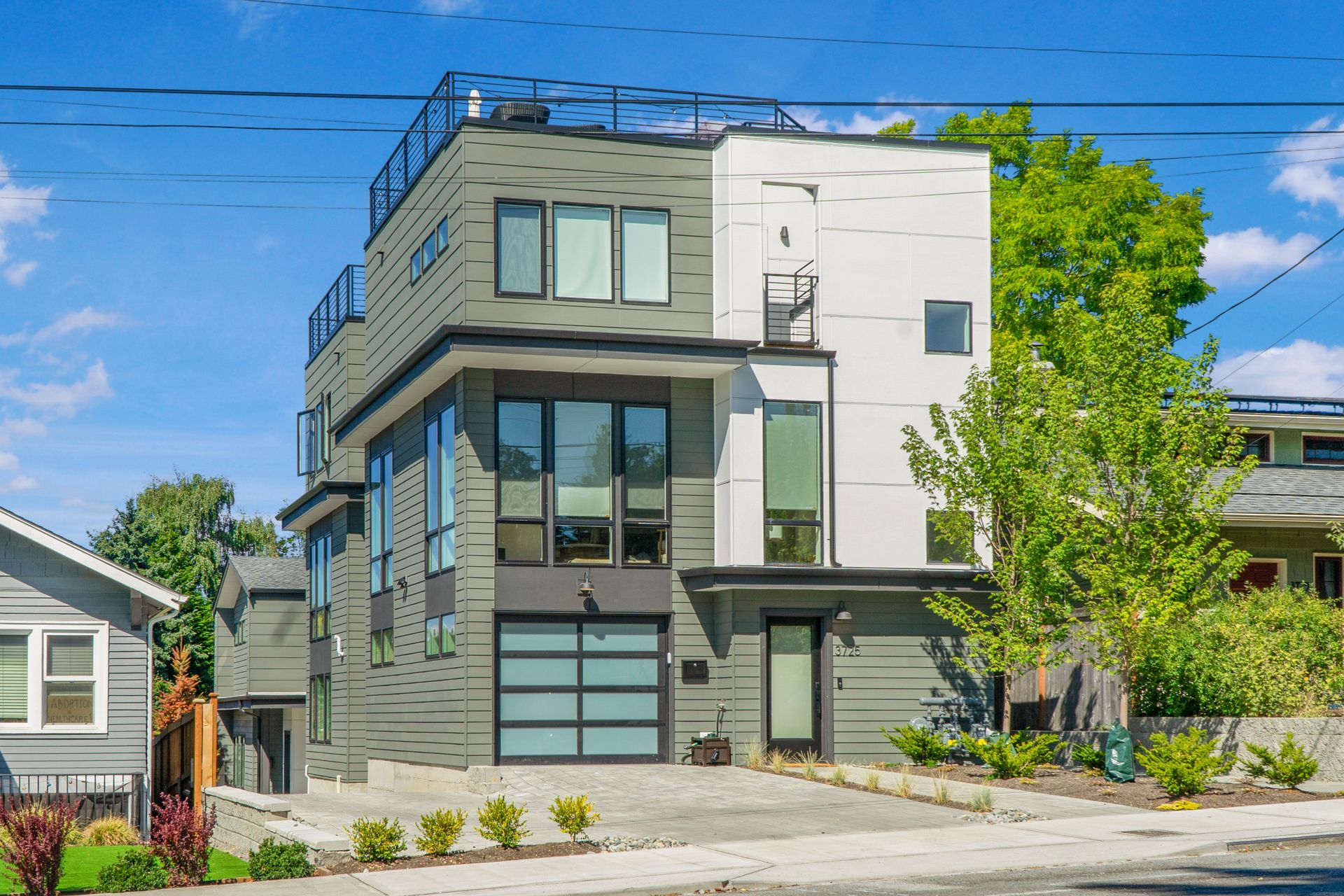 A modern house with a garage and a rooftop deck.