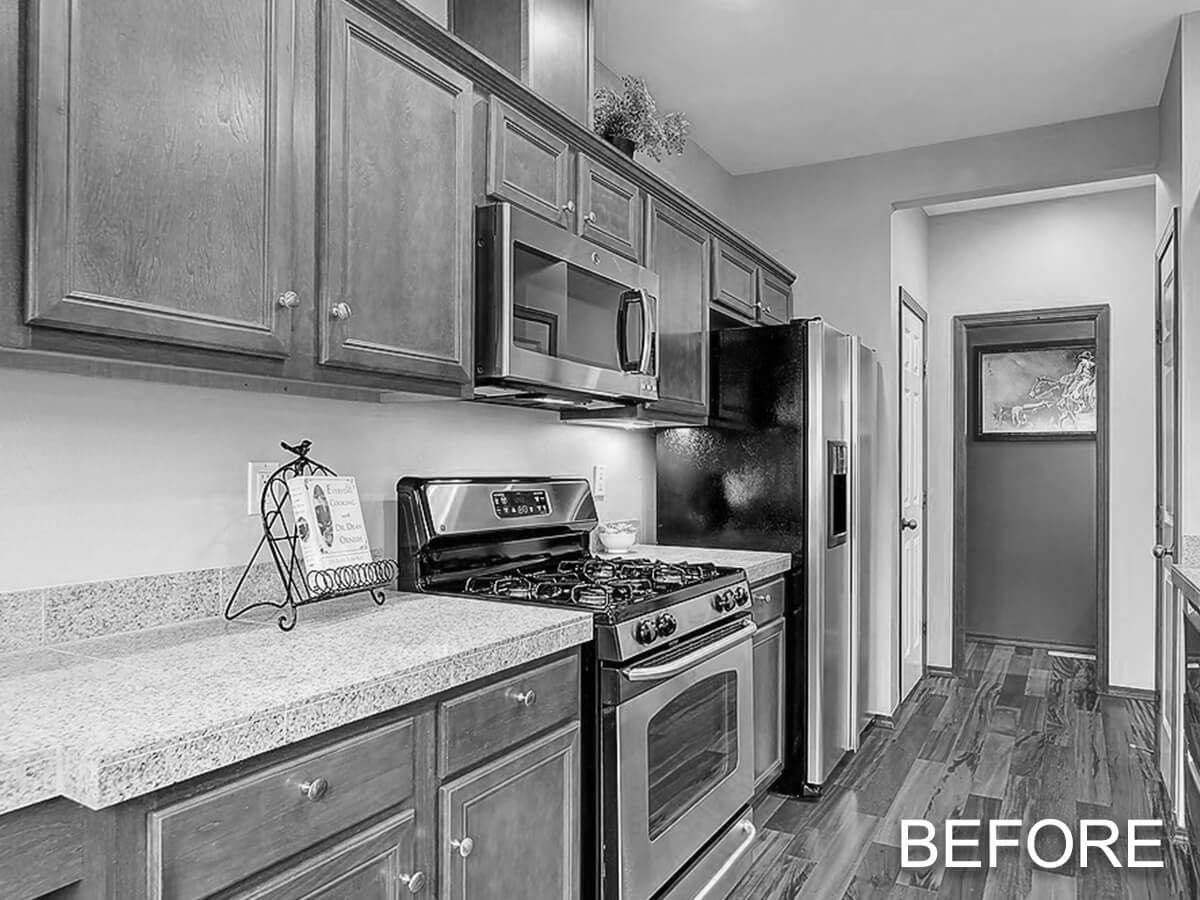 A black and white photo of a kitchen with stainless steel appliances and granite counter tops.