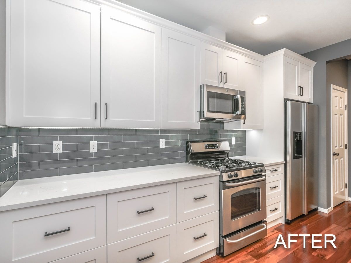 A kitchen with white cabinets and stainless steel appliances.