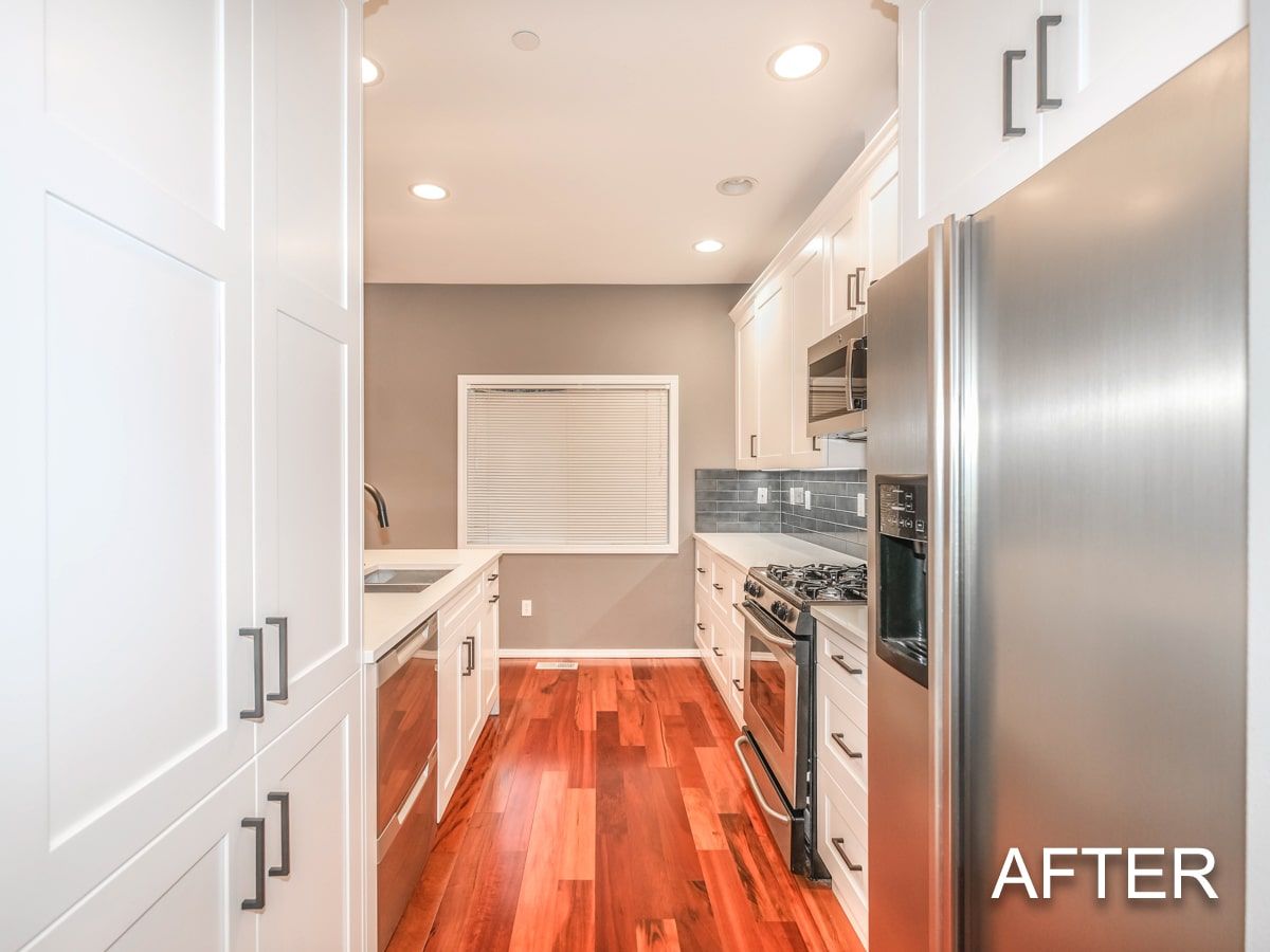 A kitchen with stainless steel appliances and hardwood floors after being remodeled