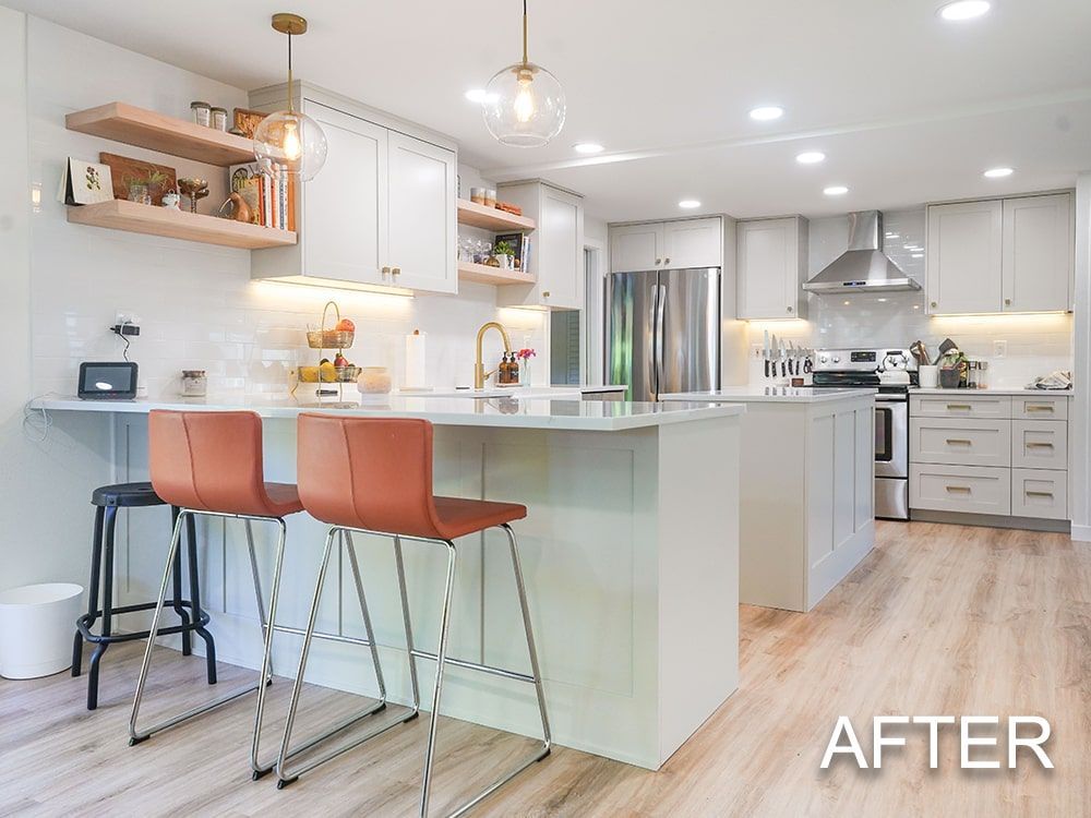 A kitchen with white cabinets , stainless steel appliances , and wooden floors.