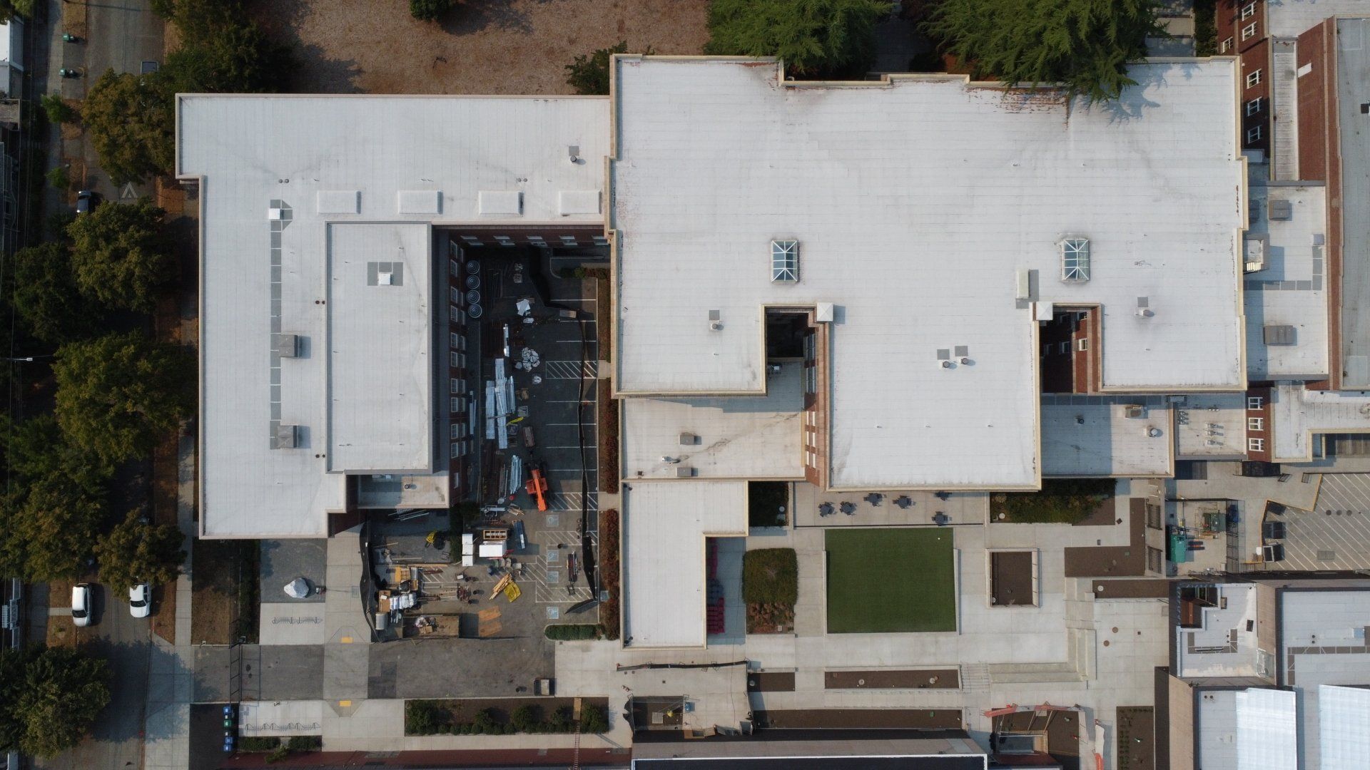 An aerial view of a large building with a white roof.