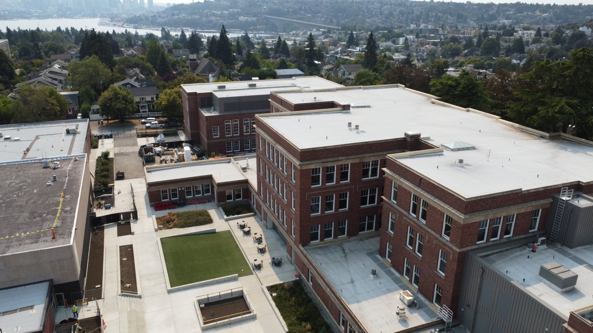 An aerial view of a large brick building with a white roof