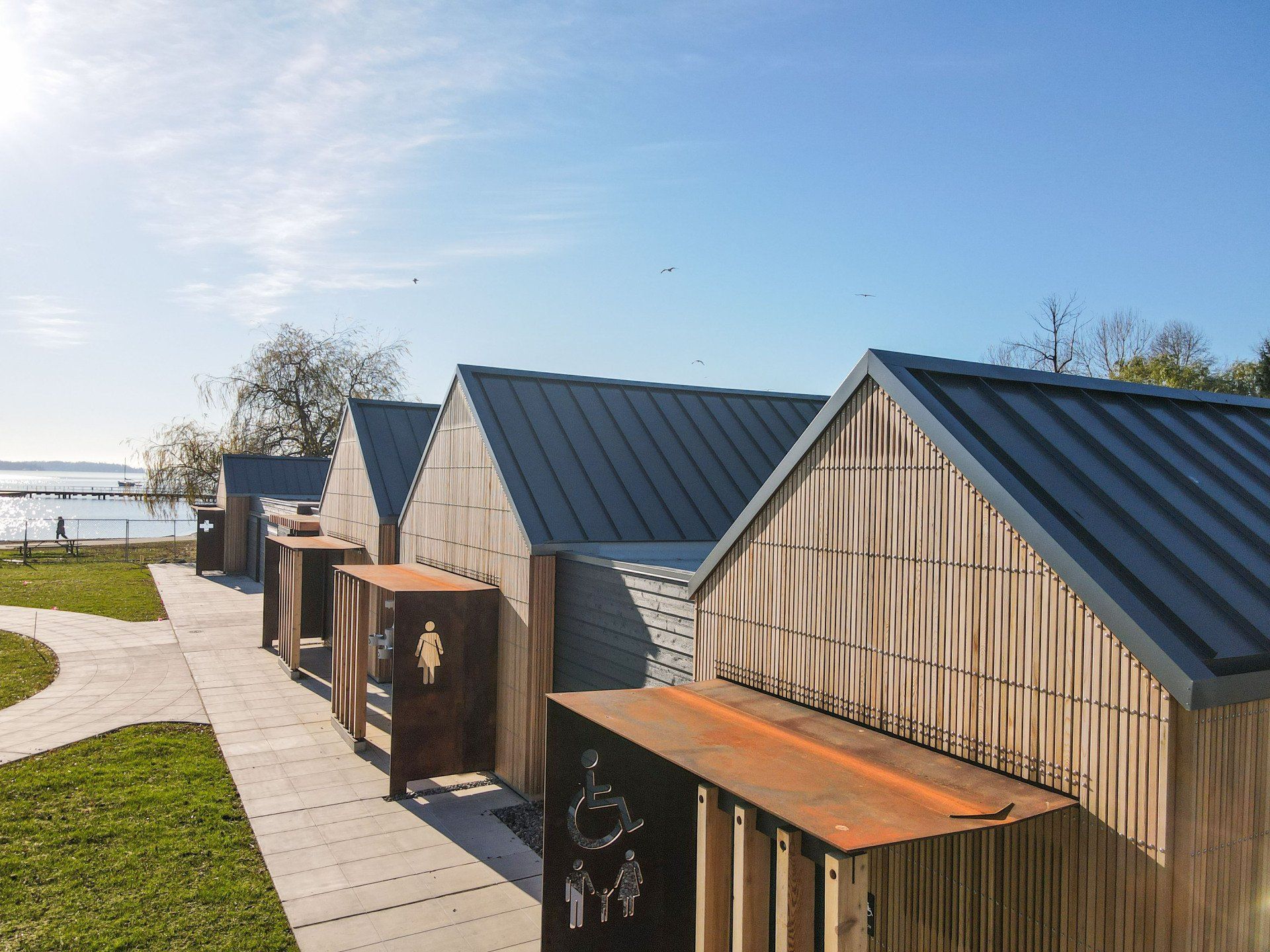 A row of wooden houses with a metal roof are lined up next to each other.