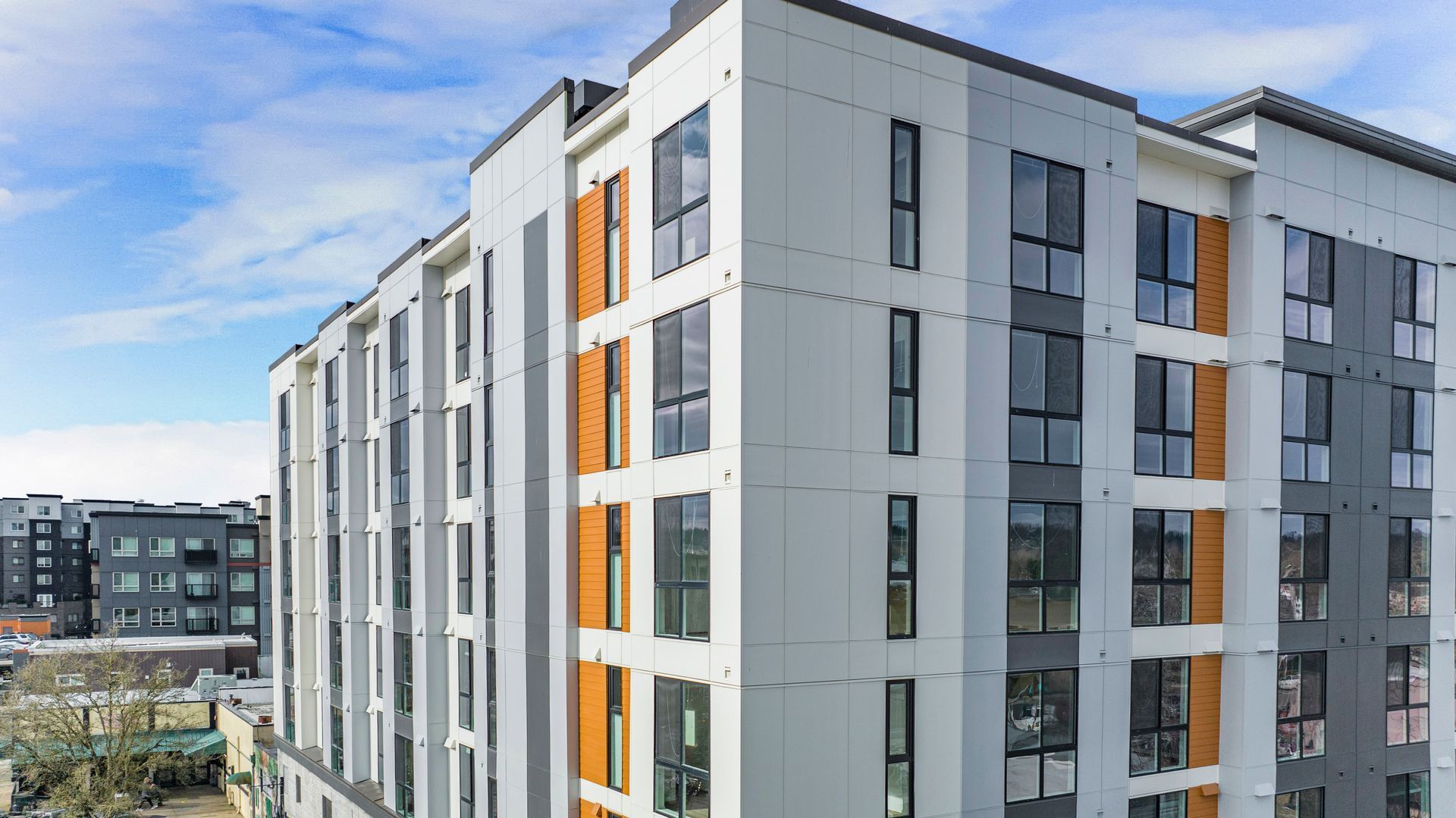 A large apartment building with a lot of windows and a blue sky in the background.