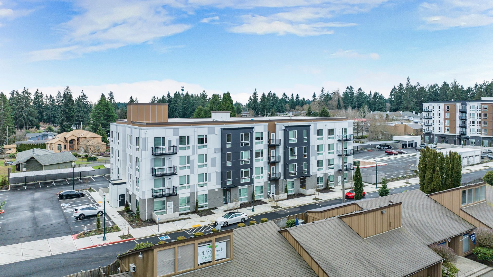 An aerial view of a large apartment building in a residential area.