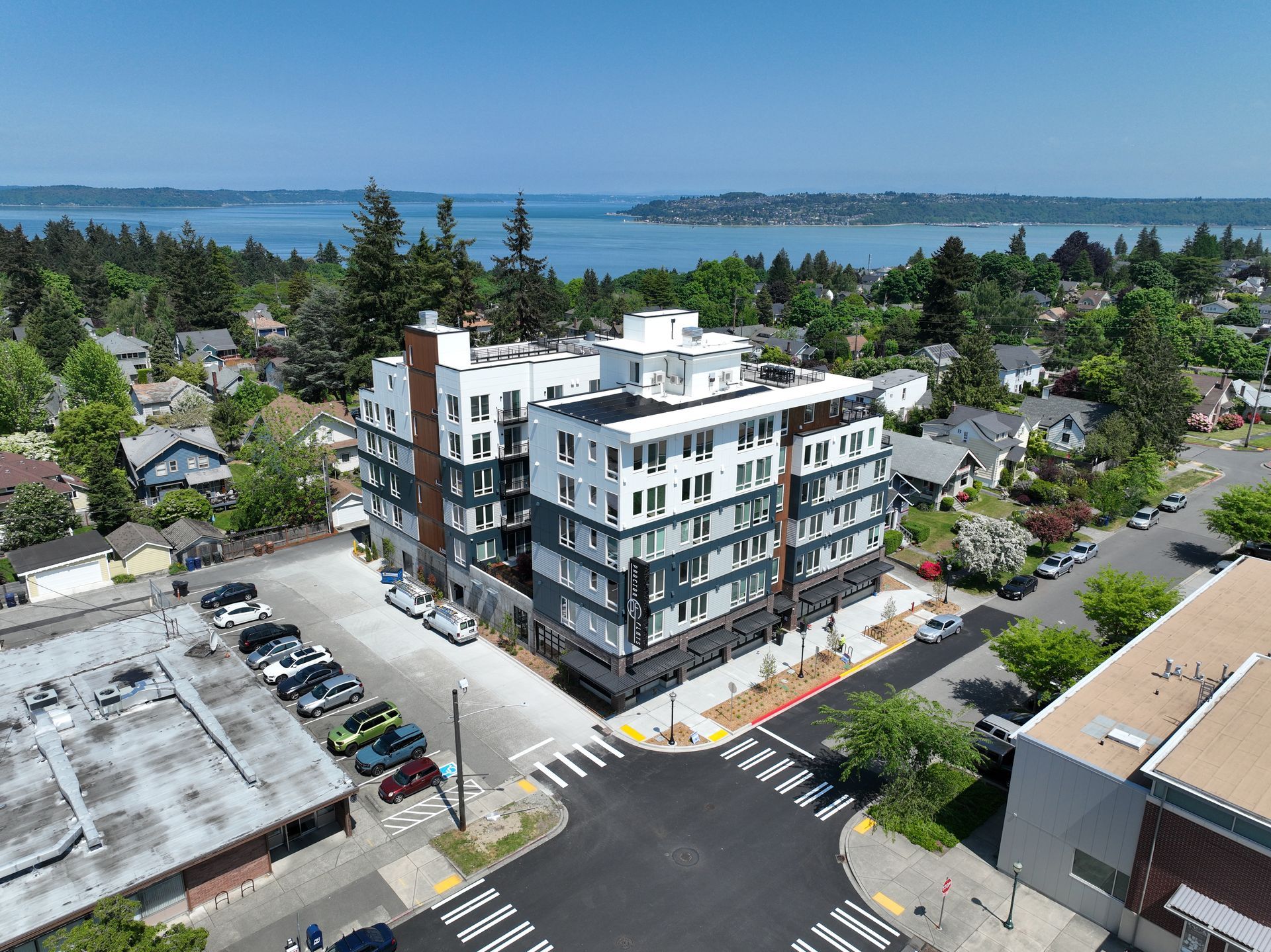 An aerial view of a building in a city with a lake in the background.