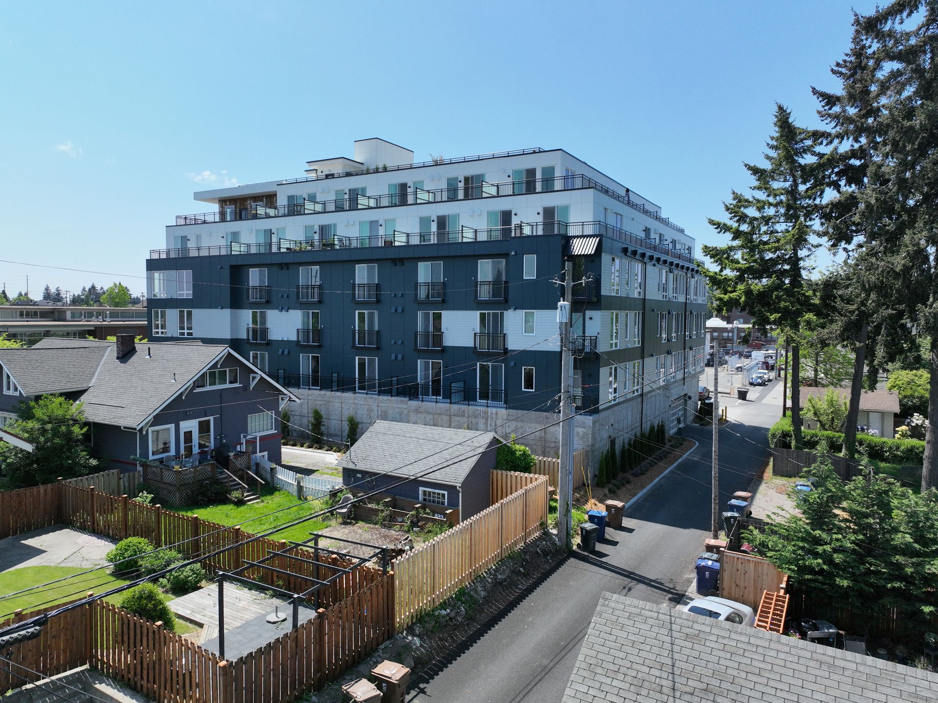 An aerial view of a large apartment building surrounded by houses and trees.