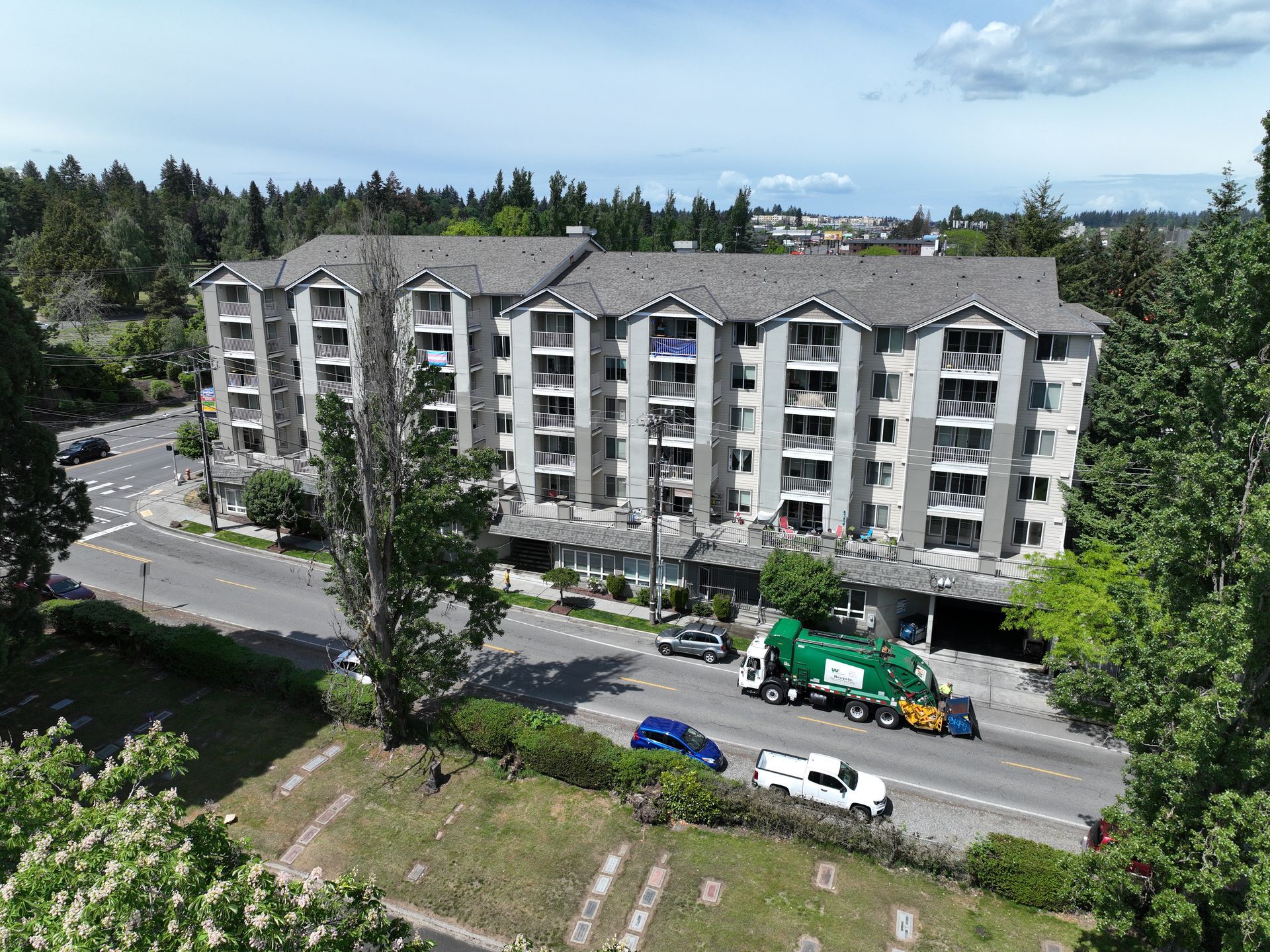 An aerial view of a building with a garbage truck parked in front of it.