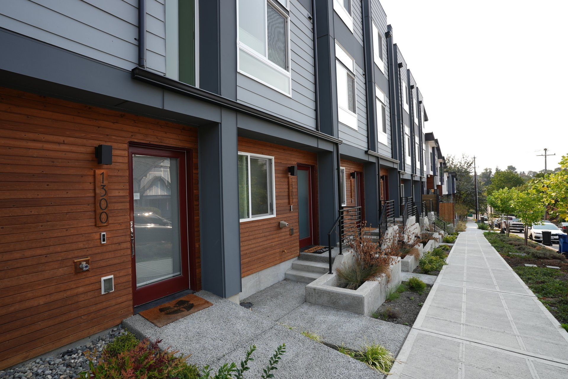 A row of apartment buildings with a sidewalk in front of them