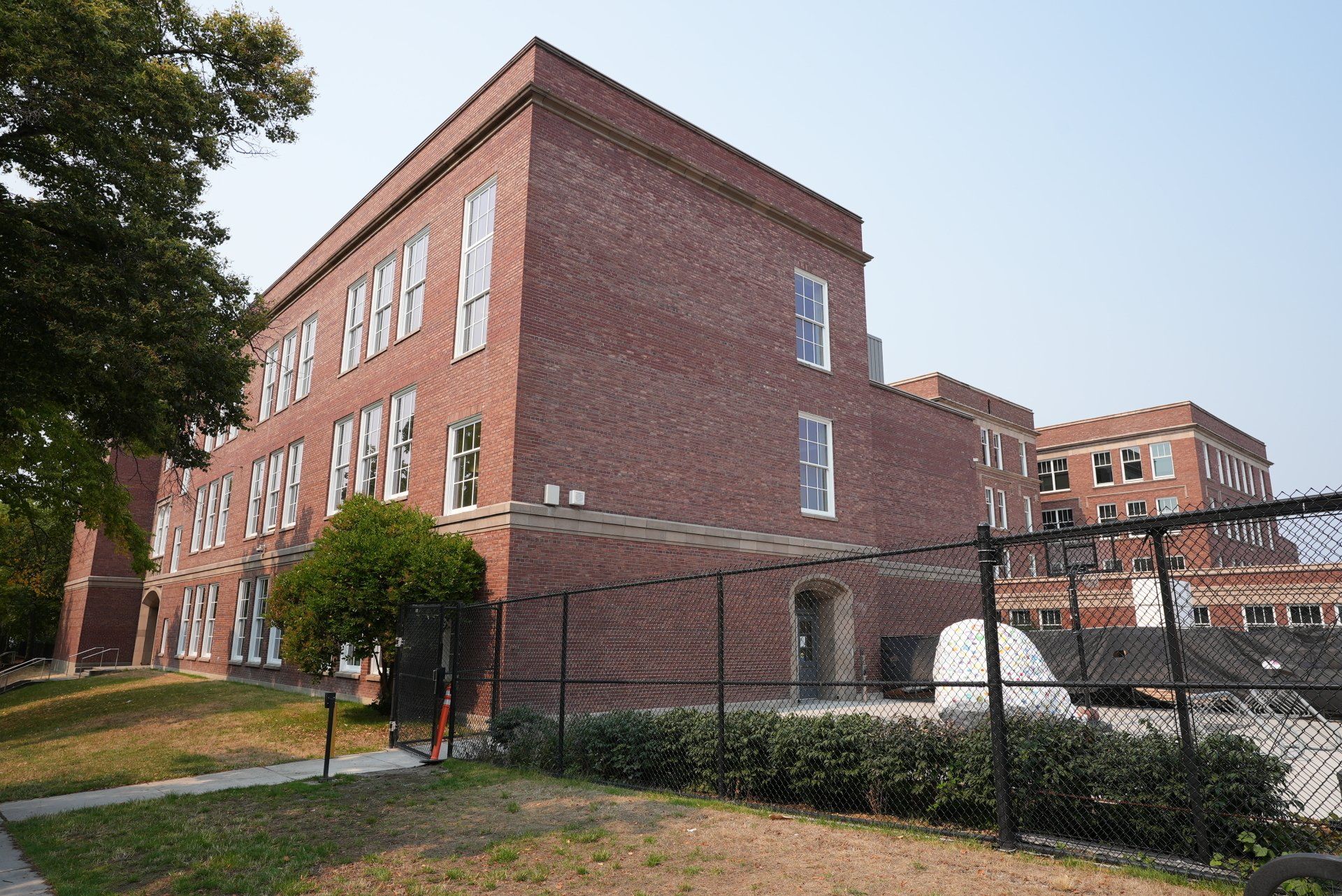 A large brick building with a chain link fence in front of it.