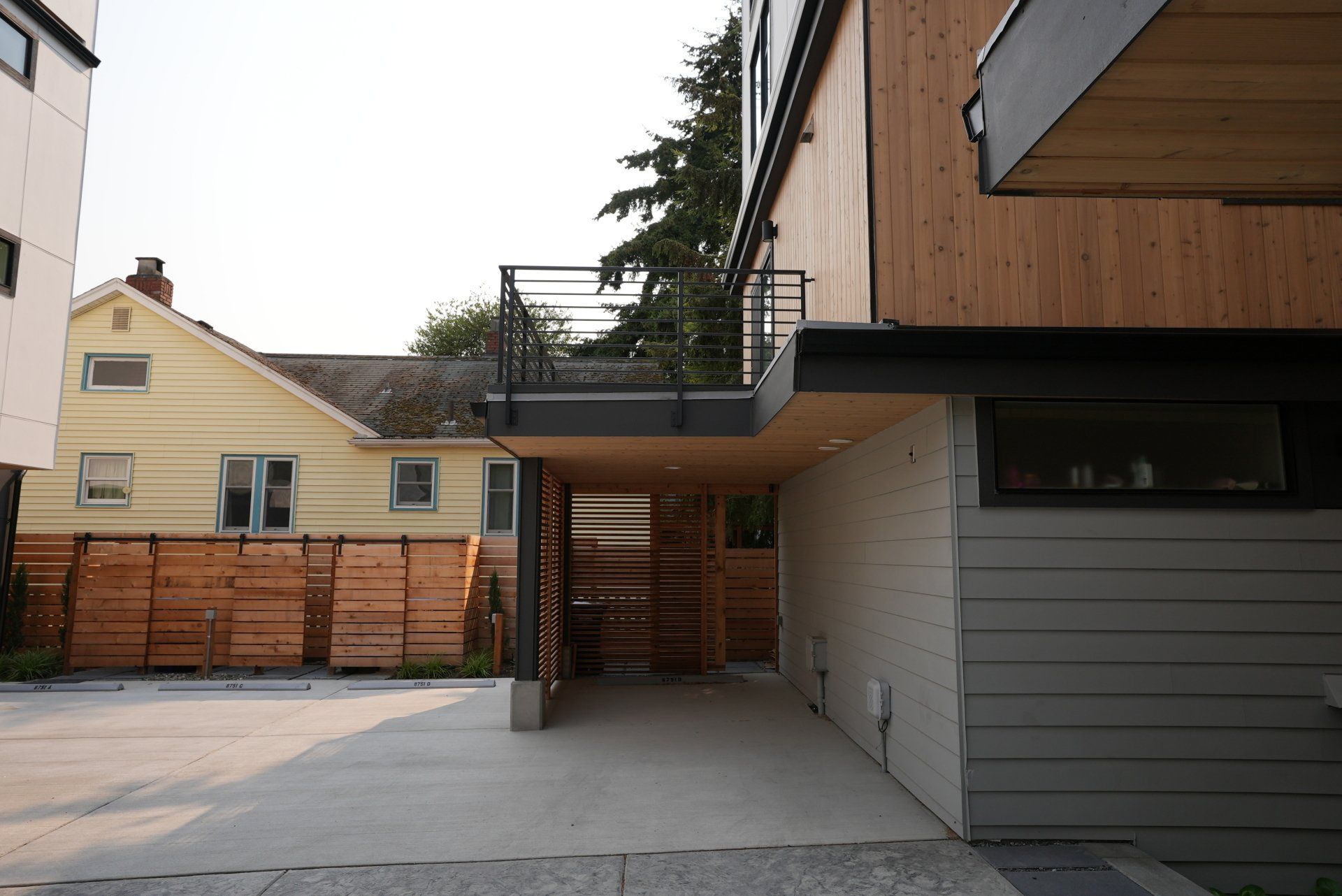 A driveway leading to a house with a balcony