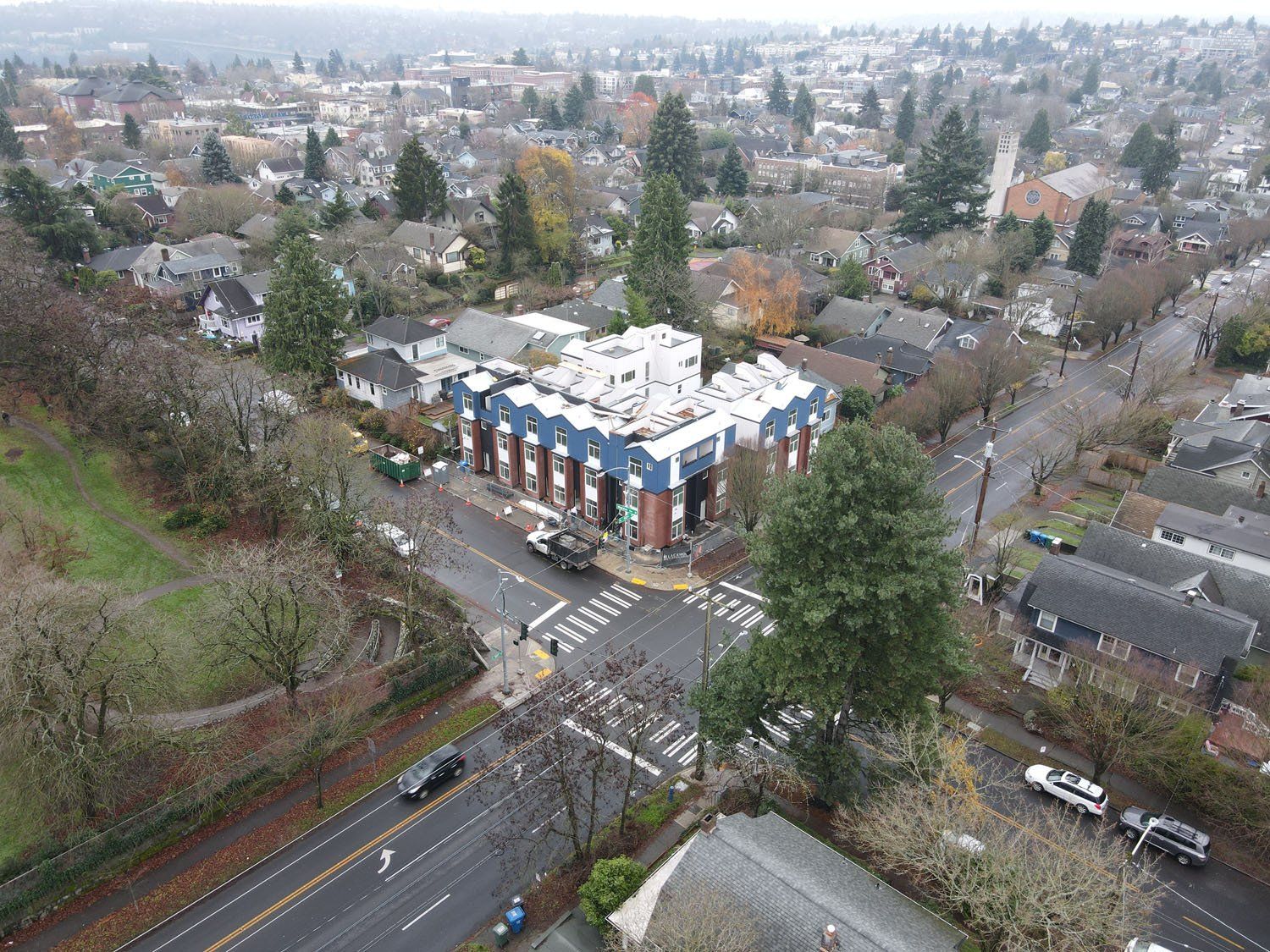 An aerial view of a city with a building in the middle of the street.