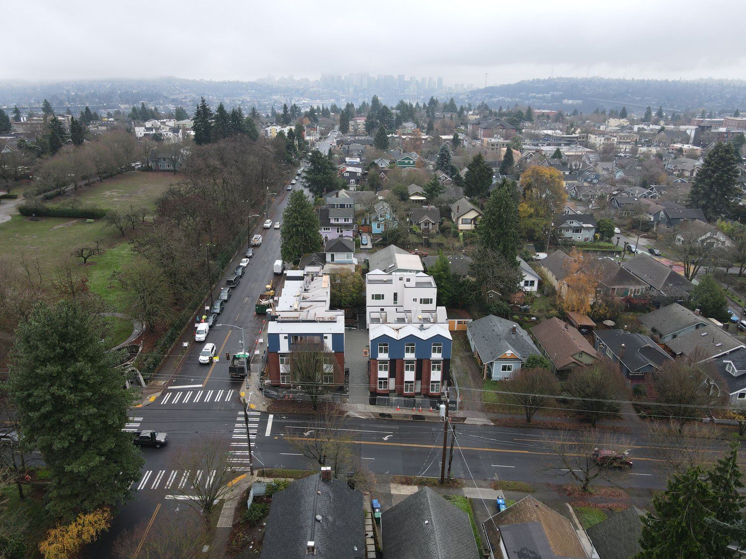 An aerial view of a city with a building in the middle of the street.