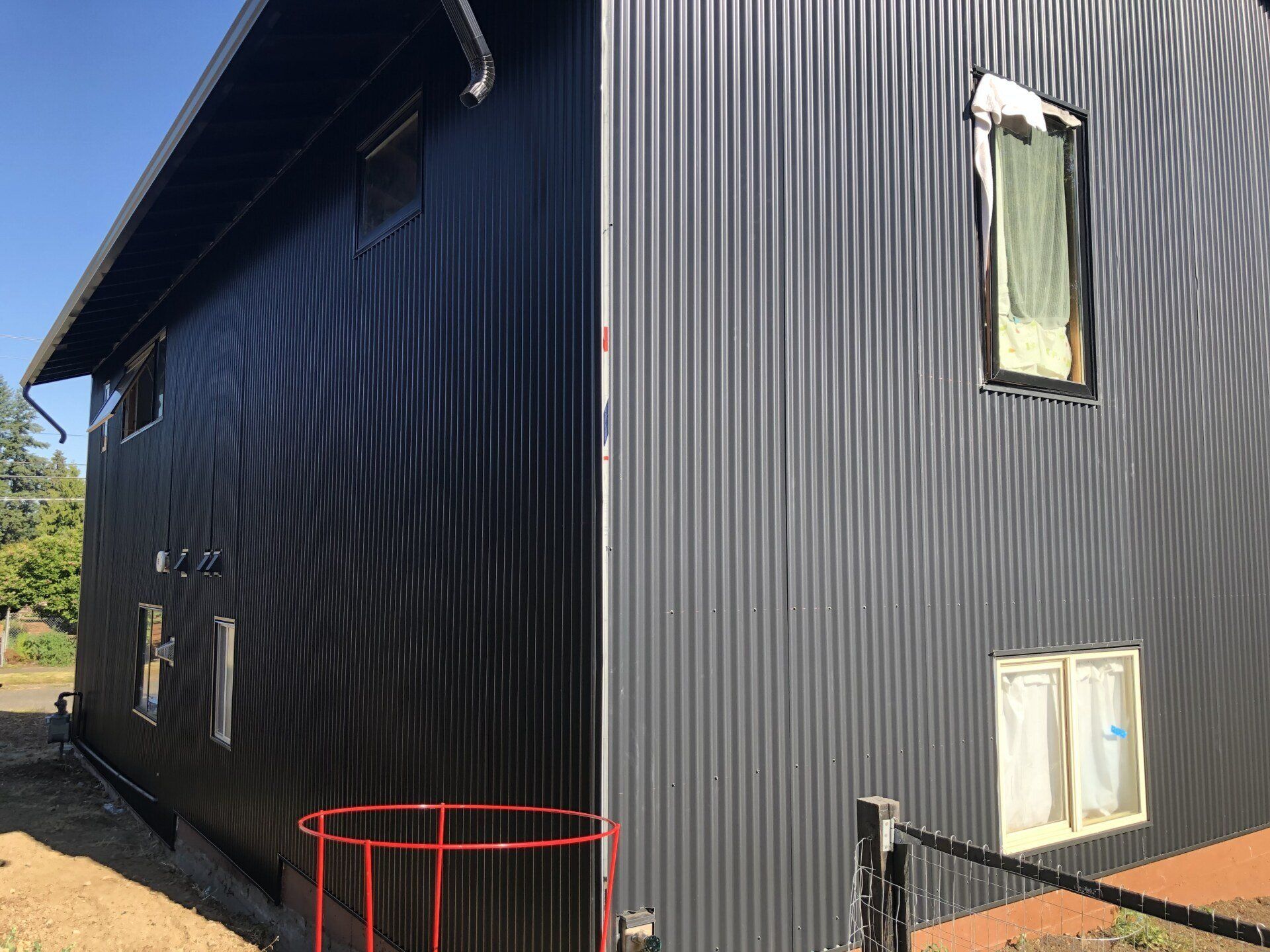 A black building with a red staircase leading up to it.