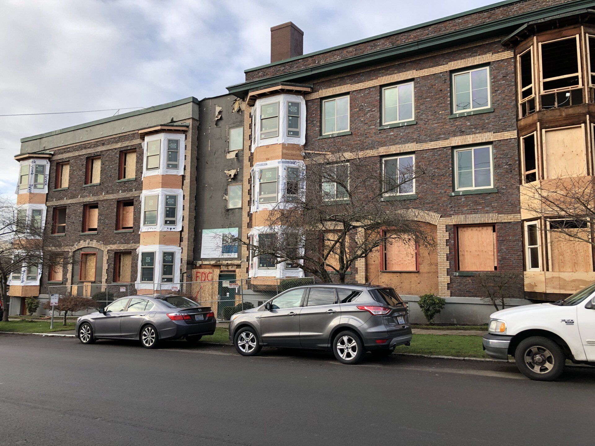 A building with a lot of windows and cars parked in front of it.