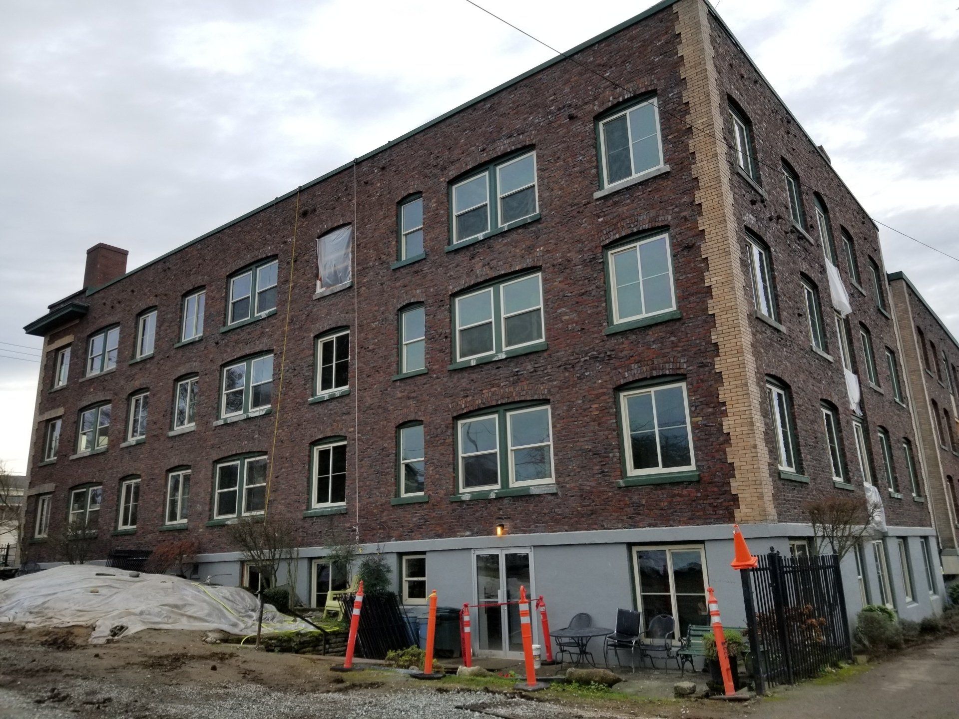 A large brick building with a lot of windows on a cloudy day.