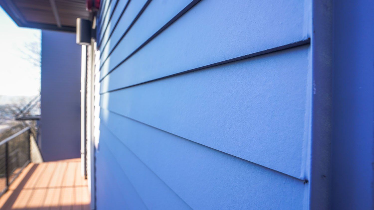 A close up of a blue house with a balcony.