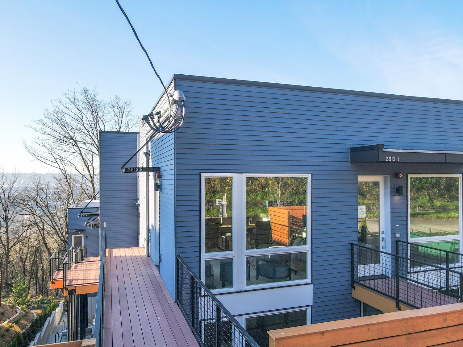 A blue house with a balcony and a lot of windows