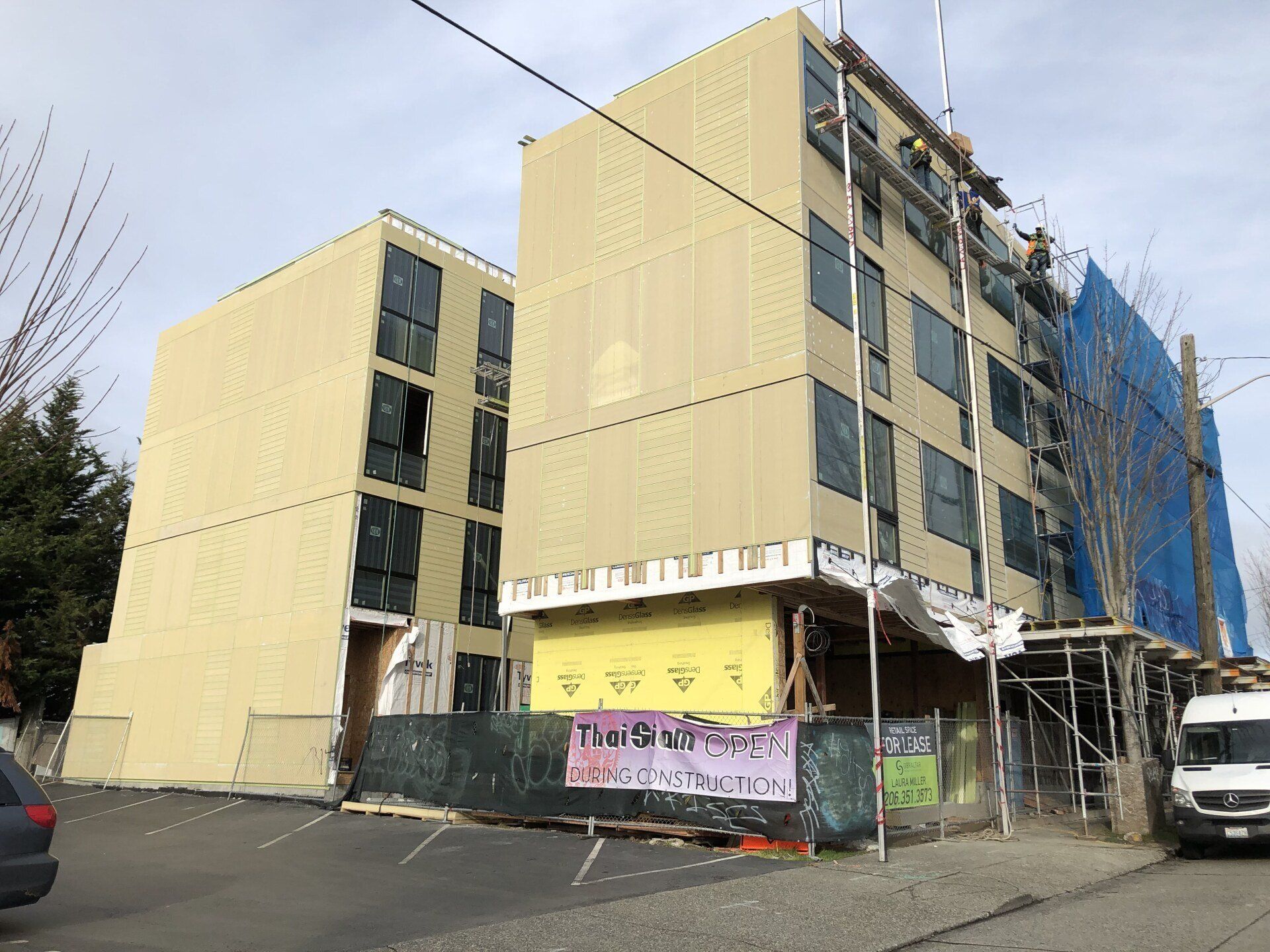 A large building is being remodeled with a sign that says ' tropical resort ' on it.