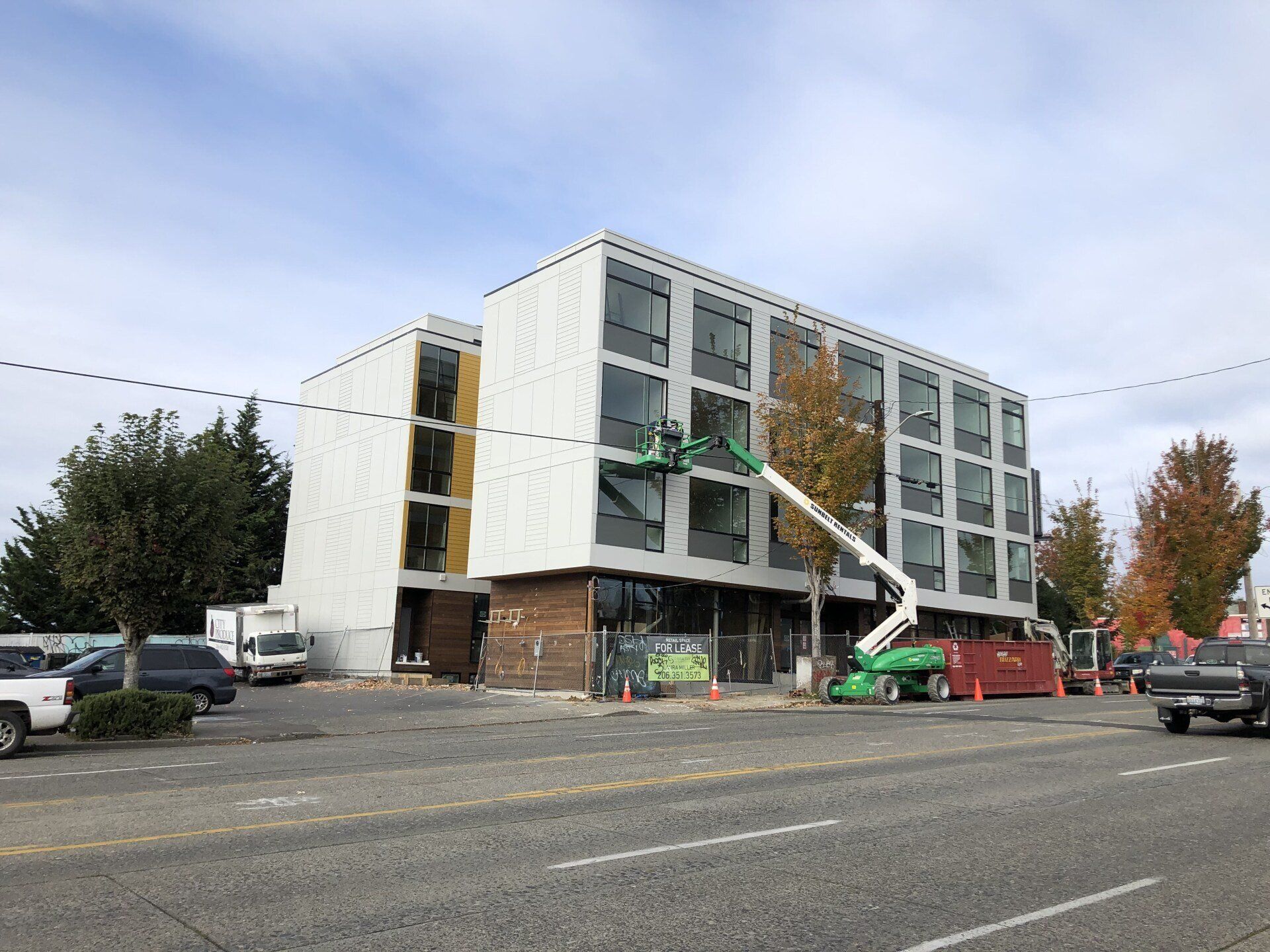 A large building under construction with a green crane in front of it.