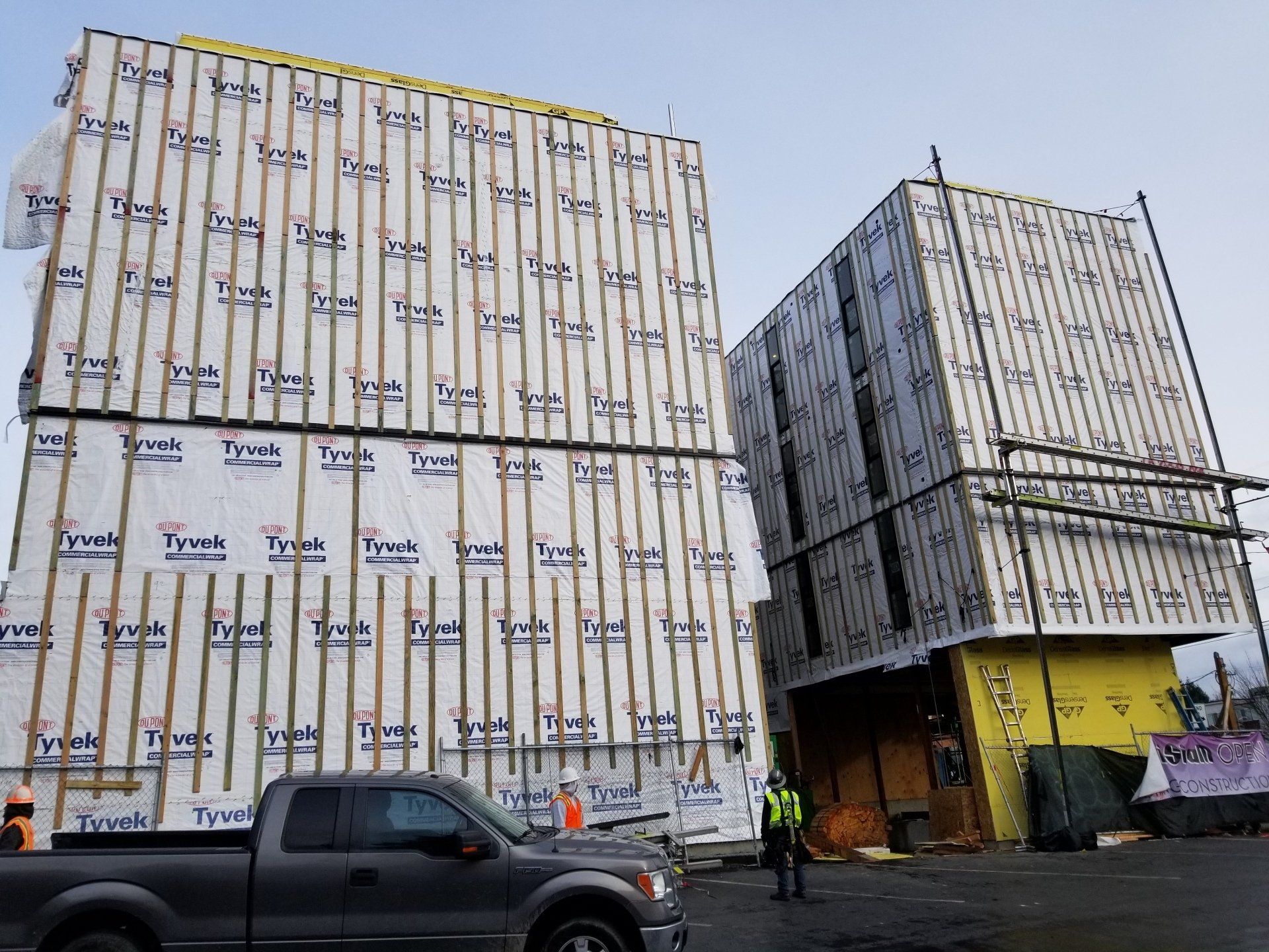 A truck is parked in front of a building under construction