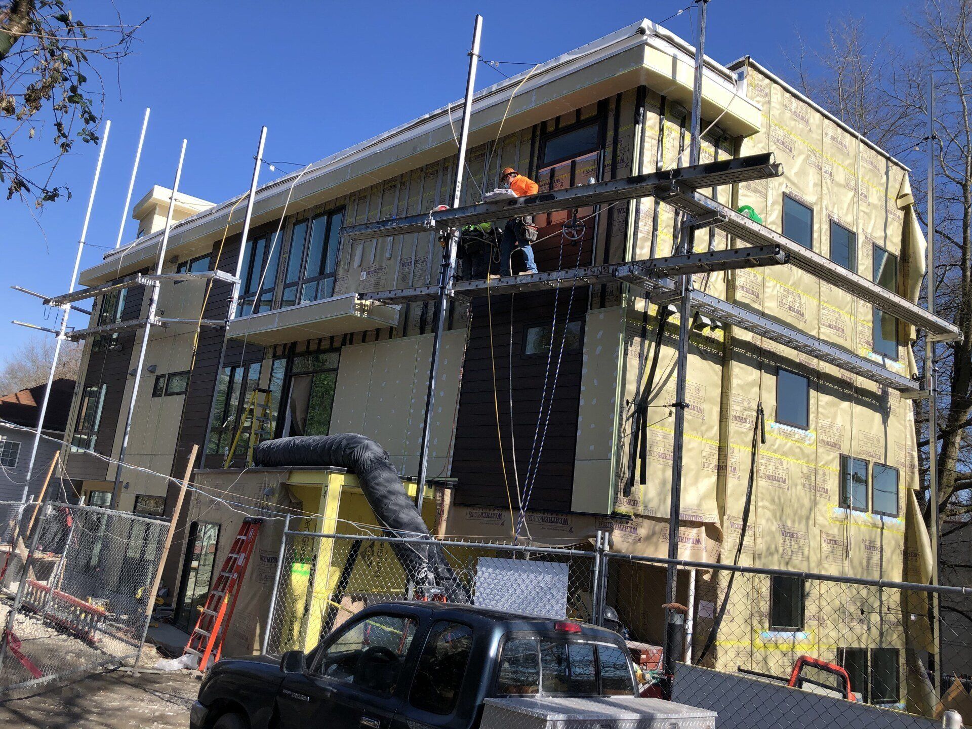 A truck is parked in front of a building under construction.