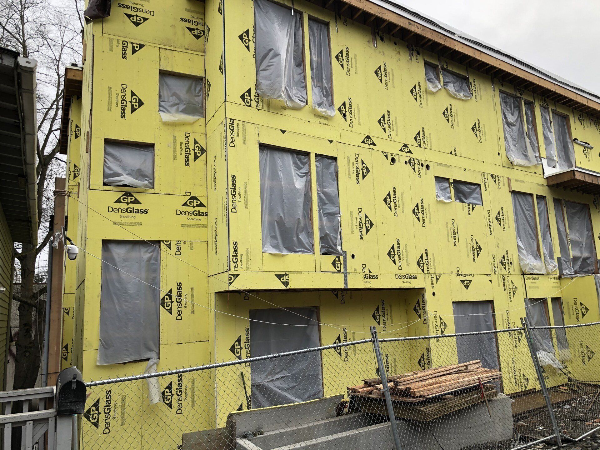 A building under construction with a lot of windows and a fence around it.