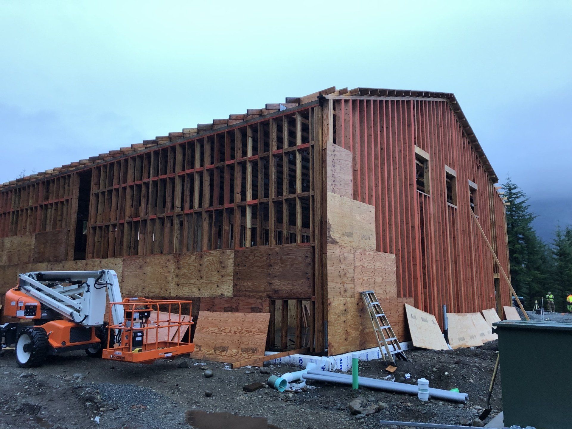 A large wooden building is being built with a crane in front of it.