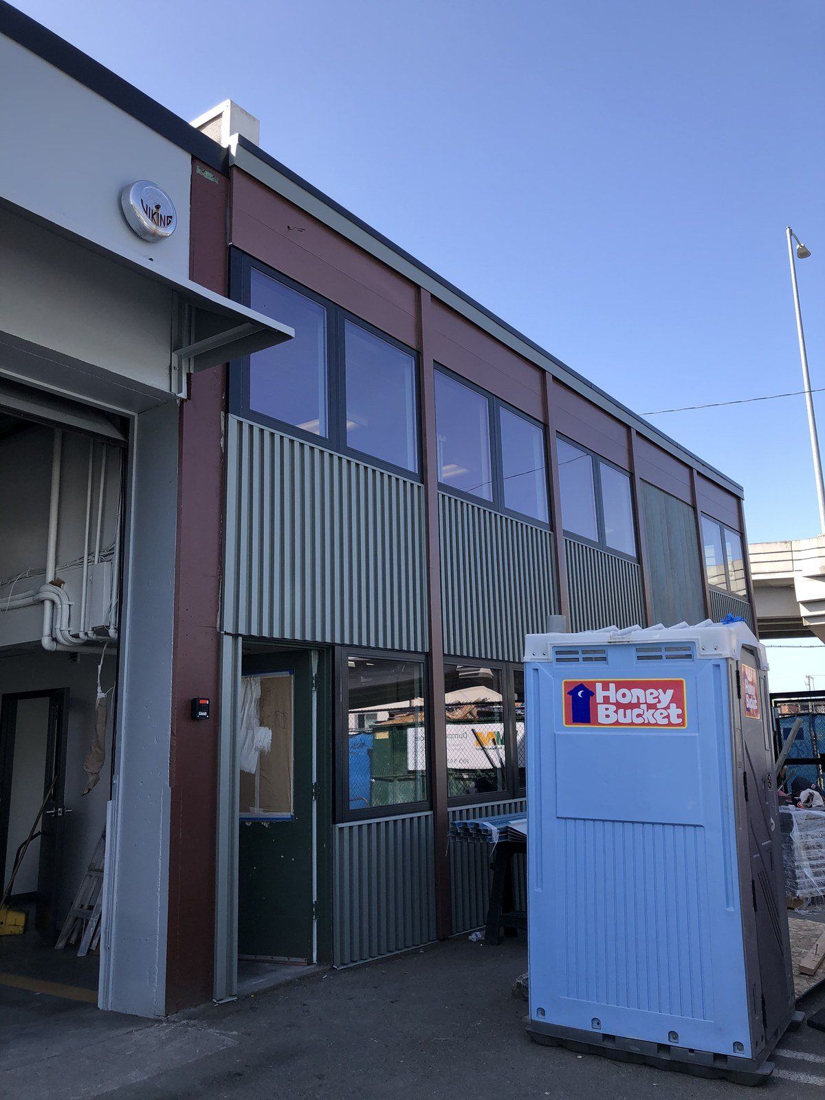 A large building with a blue portable toilet in front of it.