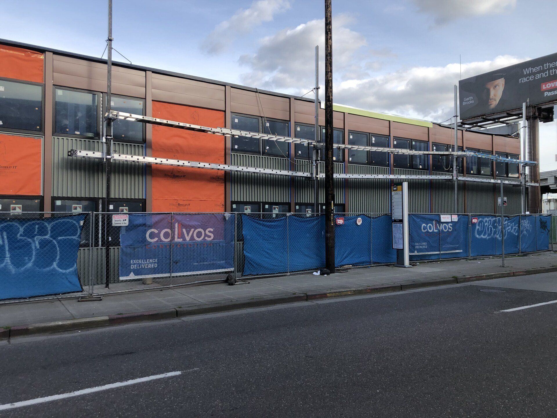 A building under construction with a blue fence around it.