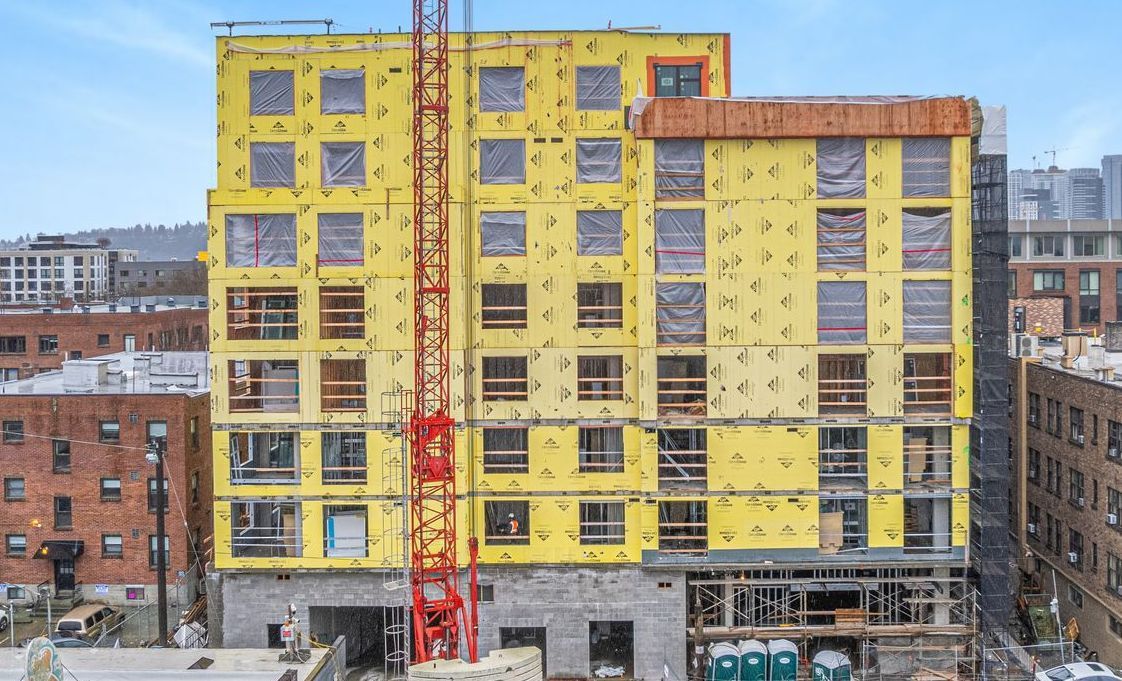 An aerial view of a building under construction in a city.