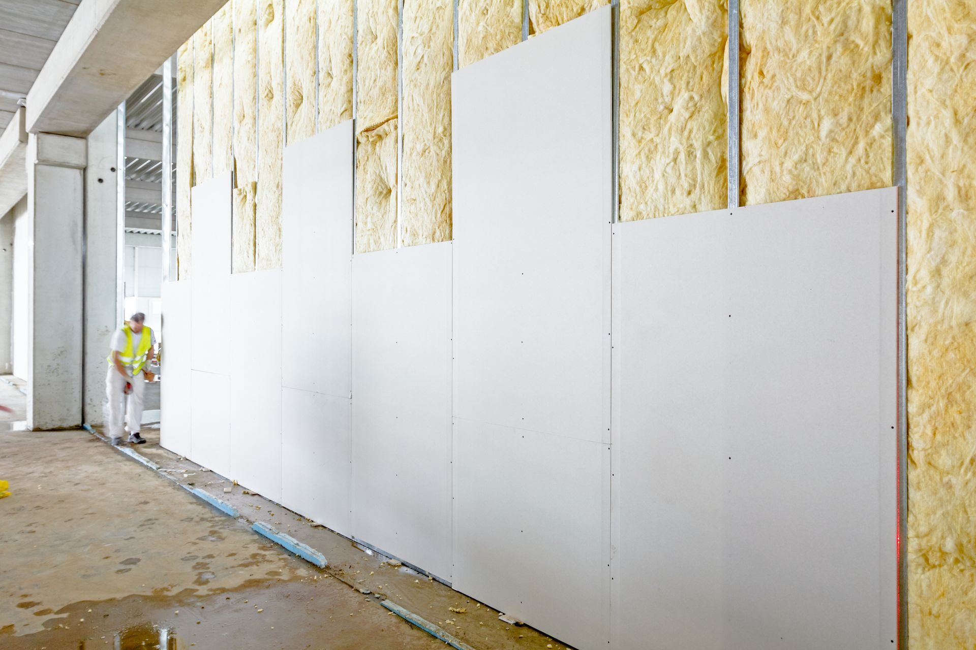 a man is standing in front of a wall with insulation on it